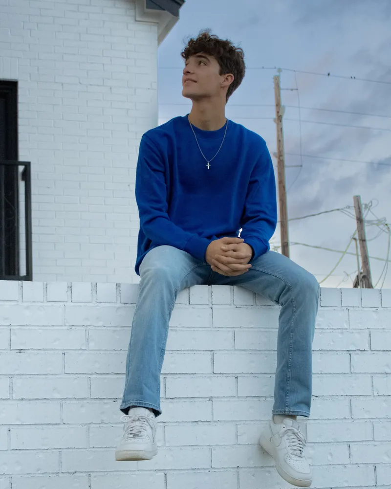 Jaden Duhon sitting on a white brick wall